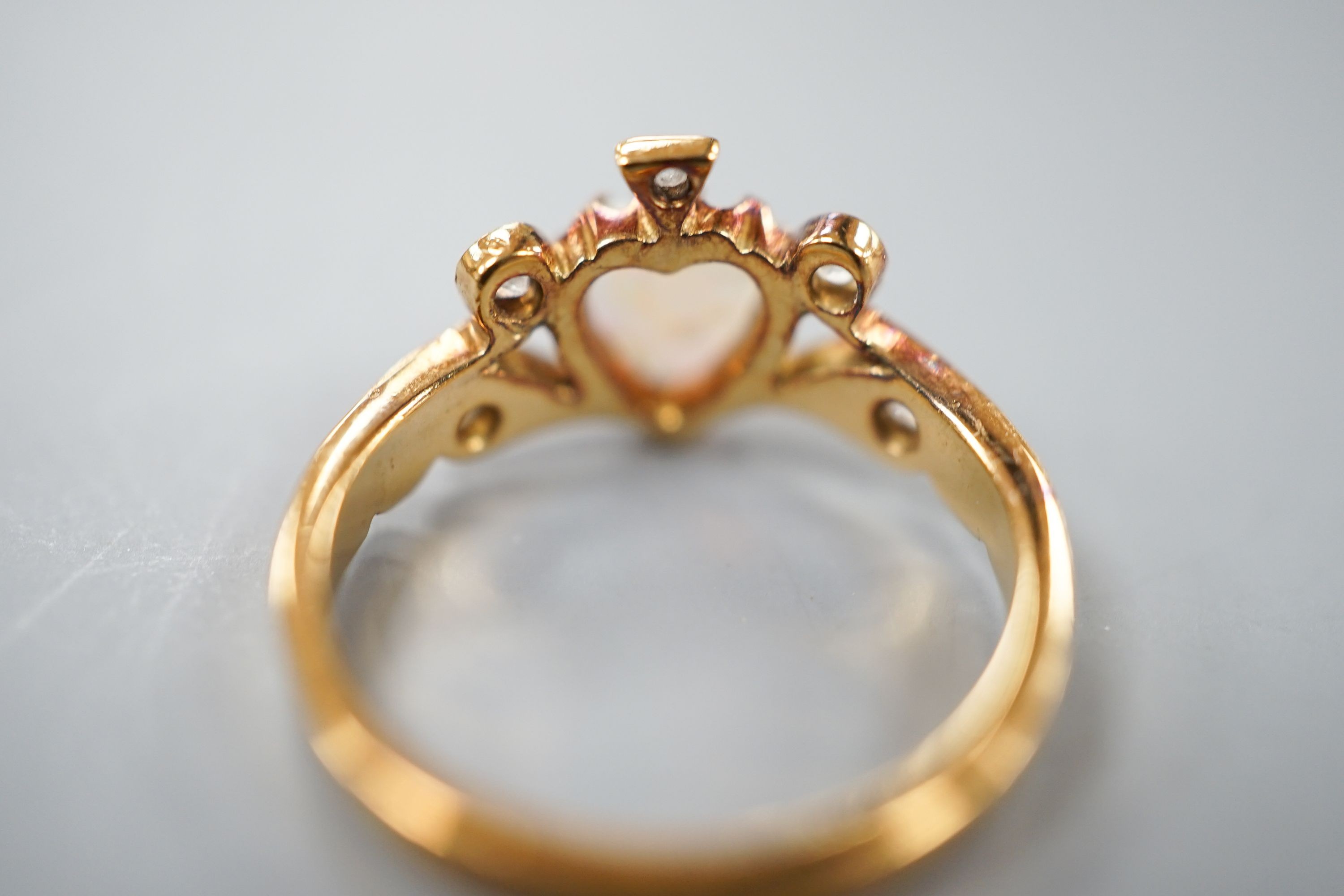 A late Victorian 18ct gold, heart shaped white opal and five stone diamond chip set dress ring, size I, gross weight 2.6 grams.
